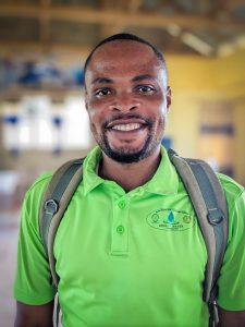 Smiling Safe Water Educator in green shirt.