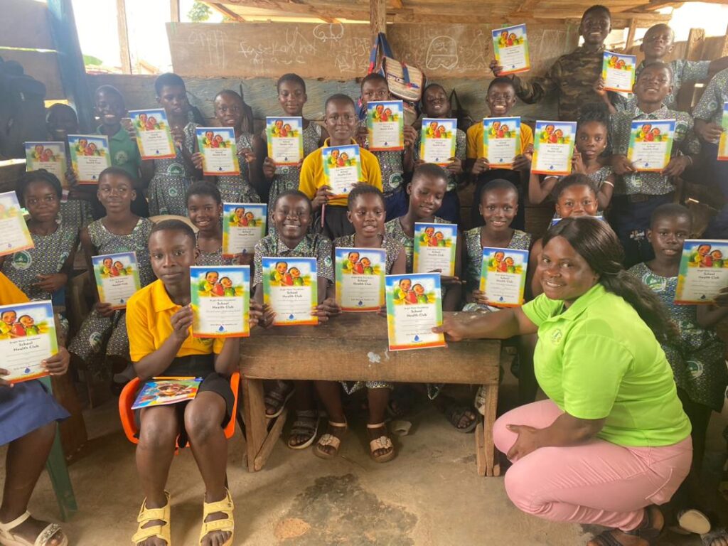 SWE poses with health club kids holding safe water certificates.