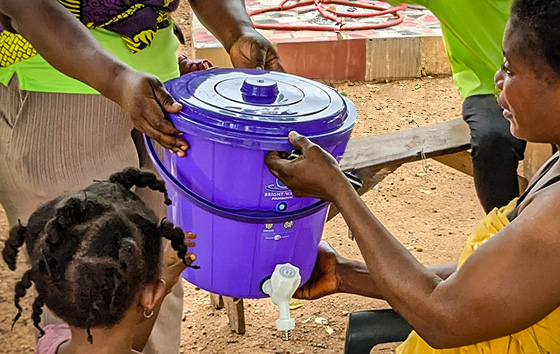 Woman receives new purple plastic drinking water container.
