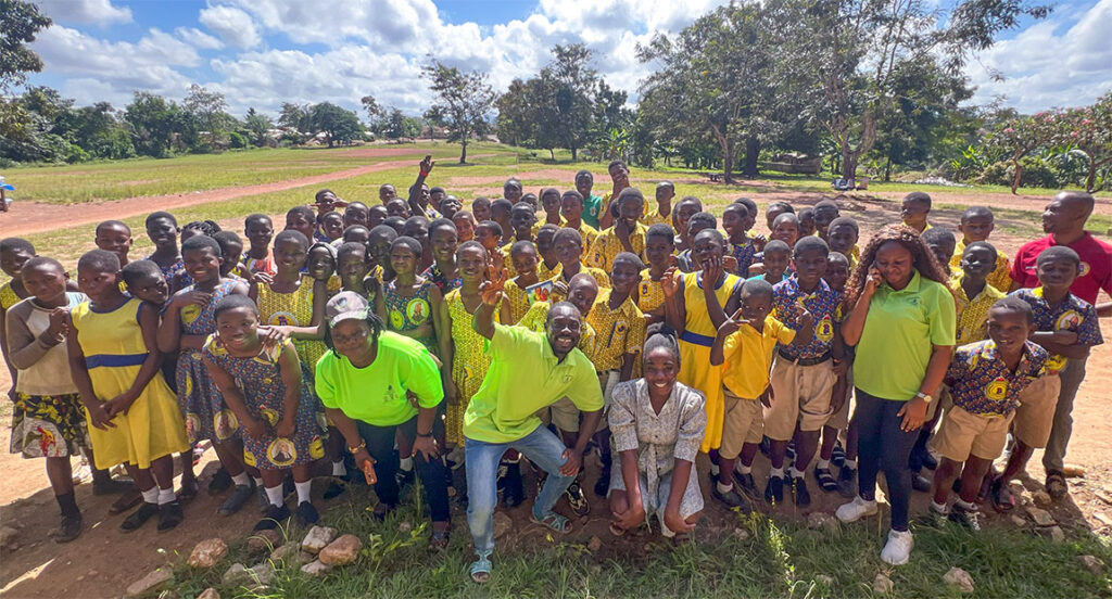 Group of smiling Ghanaian school kids, outdoors.